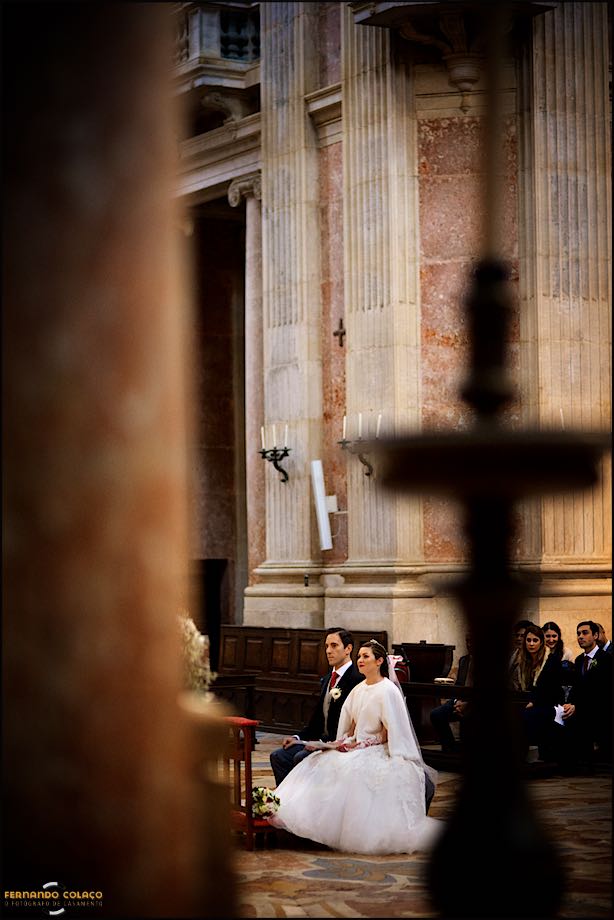 Wedding couple seated in the front of the altar in the Mafra Basílica.