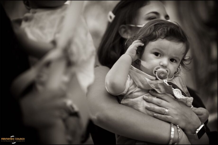 O menino que irá ser batizado na igreja, ao colo da mãe durante a celebração do seu batismo na Igreja de Nossa Senhora da Piedade em Almada.