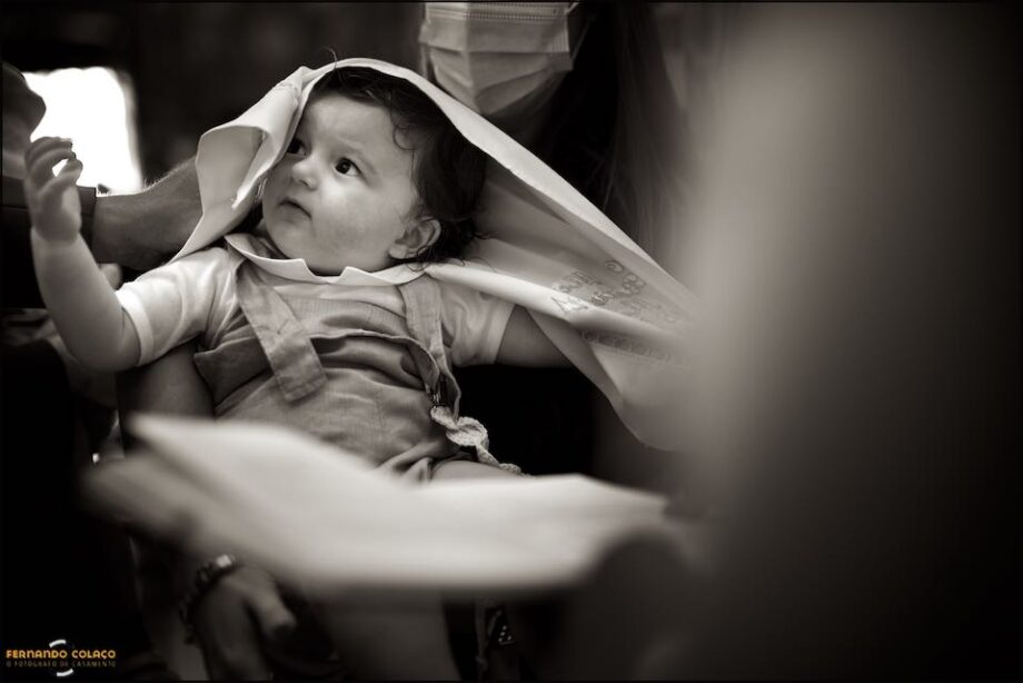 Depois de ser ungido pela água batismal na igreja Nossa Senhora da Piedade em Almada, o menino com uma toalha nos cabelos para os secar.