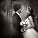 Junto a uma casa muito antiga de Sintra, o casal em frente um do outro e com o bouquet na mão da noiva, vistos pelo fotógrafo de casamento.