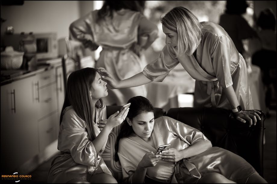Damas de honor em conversa à volta de um sofá, num momento pelo fotógrafo de casamento.