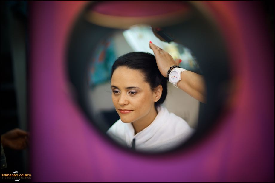 Espelho com a noiva a ser penteada, rodeado de cor purpura.