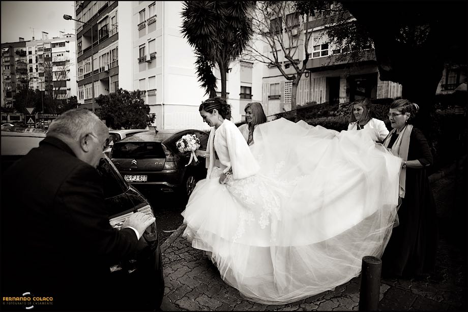 Noiva pronta para entrar no automóvel, com a ajuda da família.