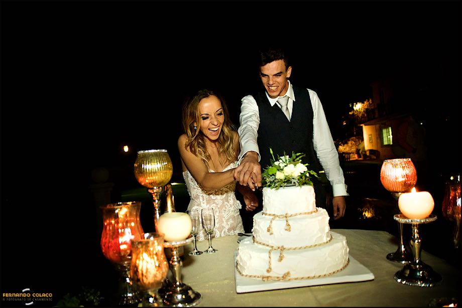 Noivos, juntos, a cortar o bolo do casamento.