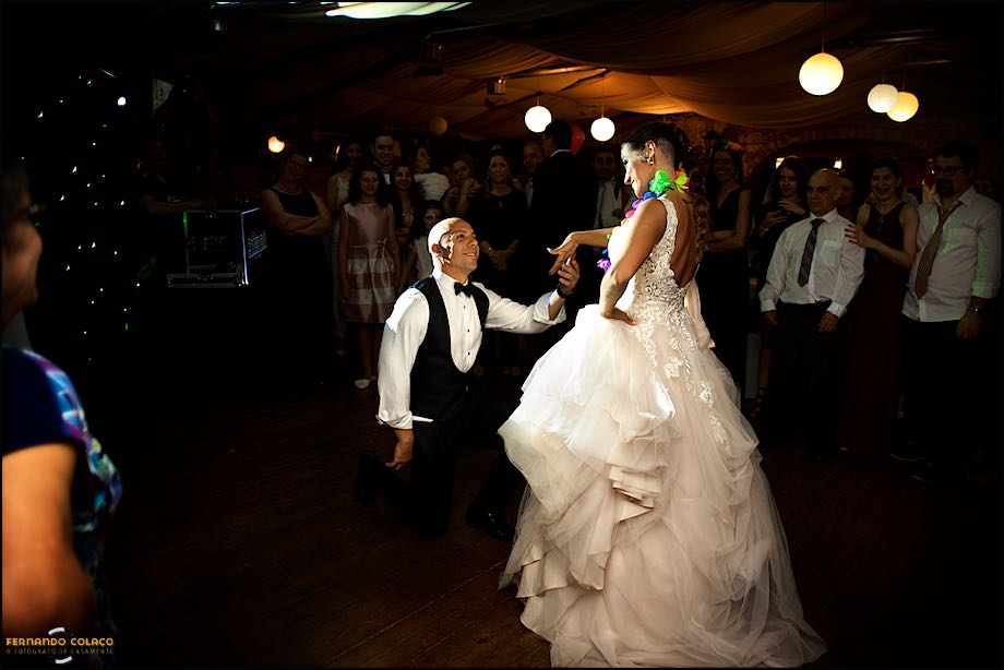 Noivo, de joelhos convida a noiva para dançar.