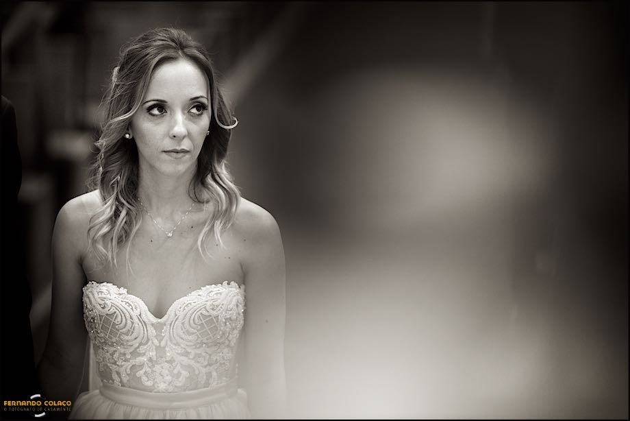 Noiva olha para o lado na cerimonia de casamento.