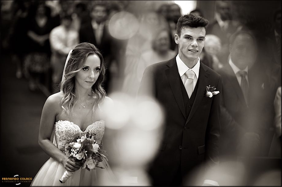 Noiva, com o bouquet na mão, ao lado do noivo, na igreja em Cascais.