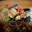 Alianças do casamento sobre flores conforme o fotógrafo de casamento as viu.