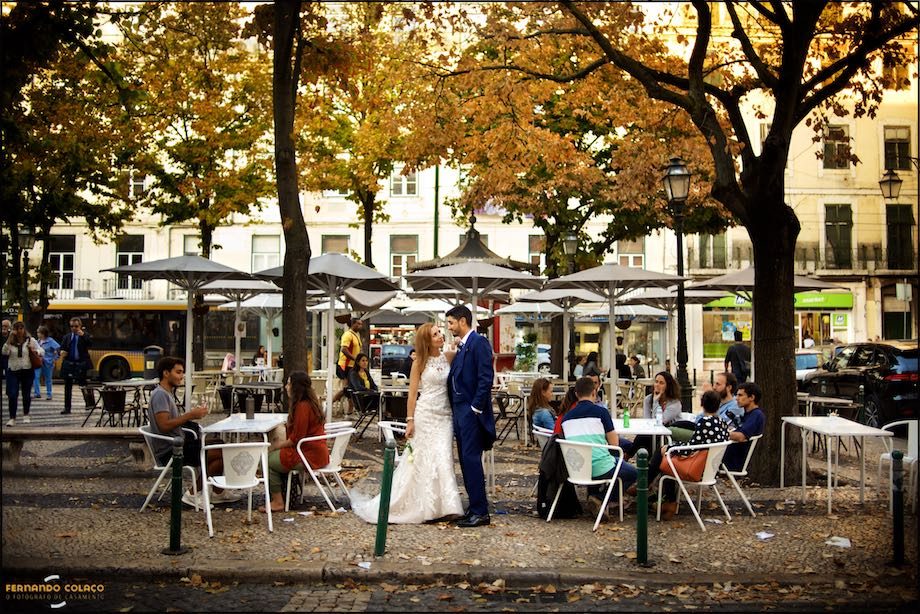 Numa praça da velha Lisboa os recém casados para o fotógrafo de casamento.