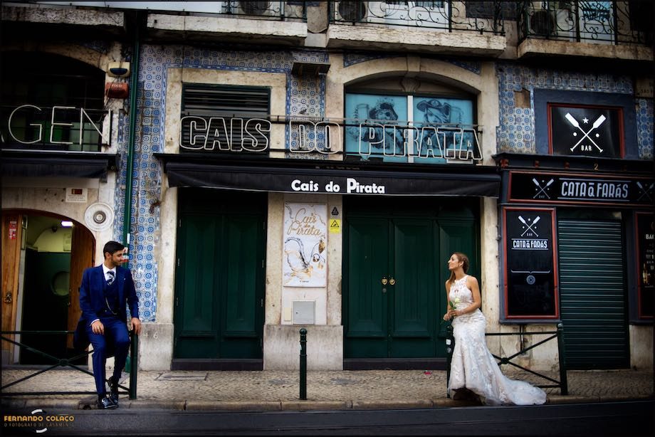 Sentados em divisórias da rua, os noivos numa rua antiga de Lisboa