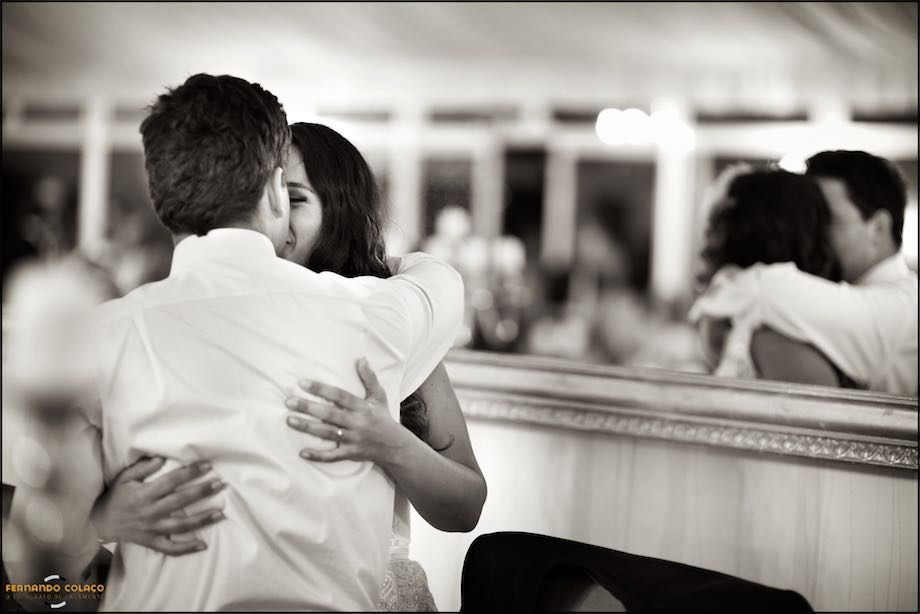 Moment of an affectionate hug, of the newly married couple with reflection in a mirror, viewed by the wedding photographer in Lisbon.