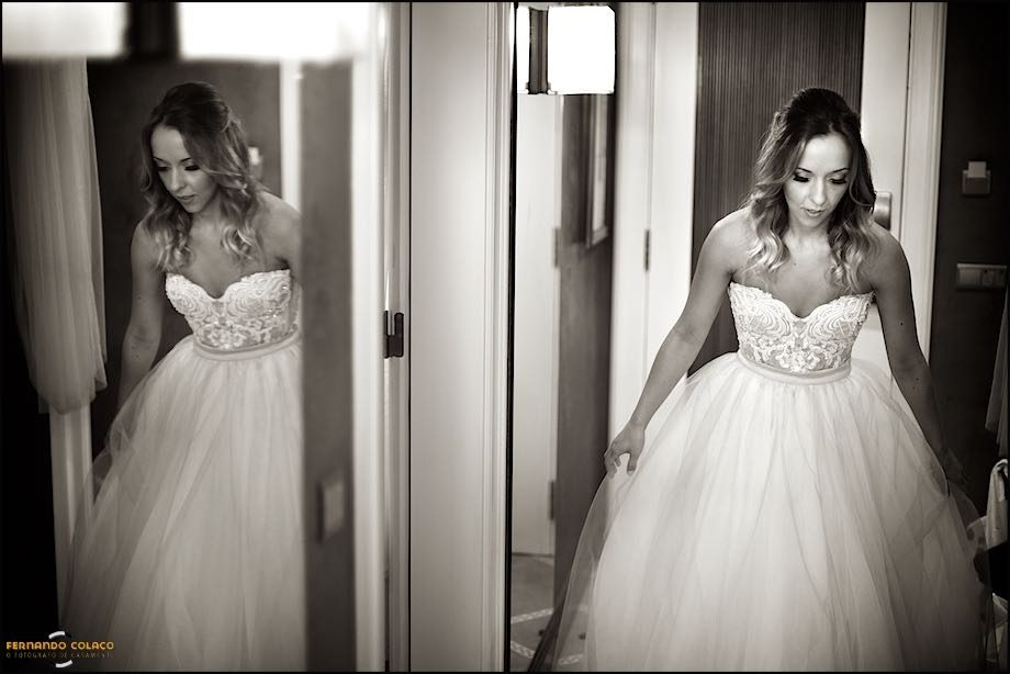 The bride, duplicated in a mirror, when she has just put on her wedding dress.