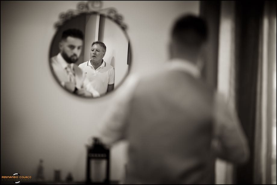 The groom's father, who didn't like to be photographed, in the deep of the round mirror on the wall.