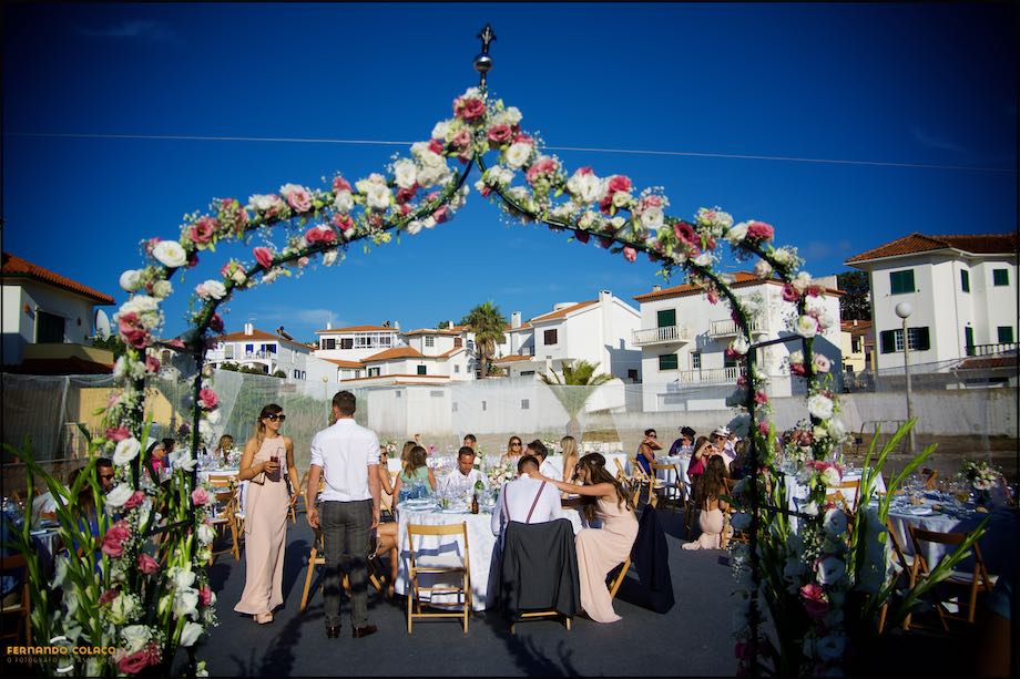 Large flowered archway at the entrance to the wedding dining space.