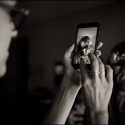 Flowers in the bride's hair on the cellphone in the hands of a wedding guest, that the wedding photographer in Lisbon took advantage of.