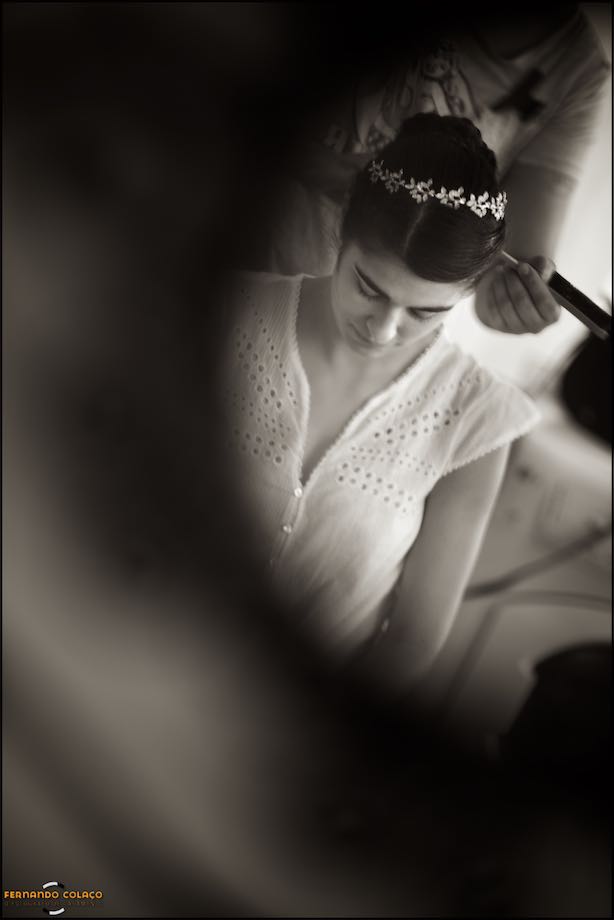 A tiara in the bride's hair, while they do her hairstyle.
