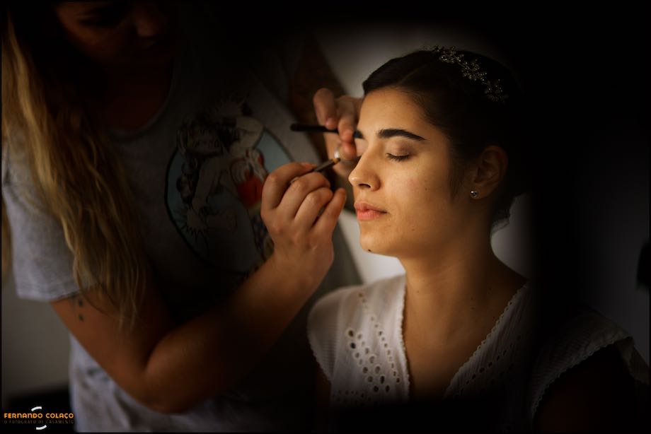 While in make-up, bride in the arms of a wedding guest, out of focus.