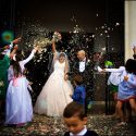 Grooms celebrate as they leave the church, after the ceremony, under rice, petals and soap bubbles, accompanied by the wedding photographer in Leiria.