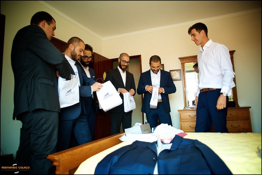Friends of the groom opening the bags with the gifts he gave them.