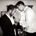 The groom helping one of his friends put a flower on his coat in a moment captured by the wedding photographer in Lisbon.