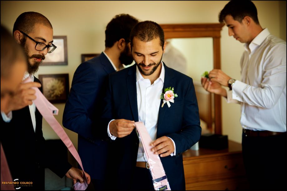 Group of groom friends starting to put on their ties.