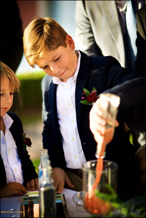 One of the bride and groom's children pour sand into a large cup, as is customary.