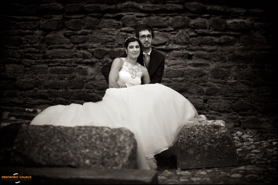 Bride and groom seen from the front inside the castle of Alandroal.