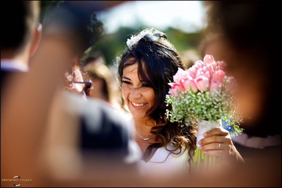 Bride with bouquet receiving congratulations from guests.