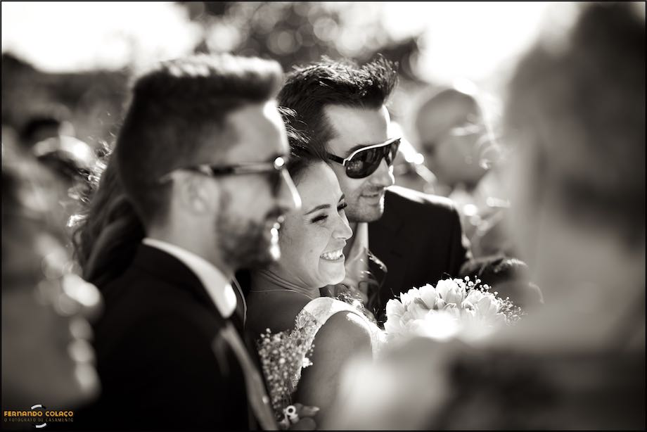 Bride posing for a photo, with guests after the wedding ceremony.