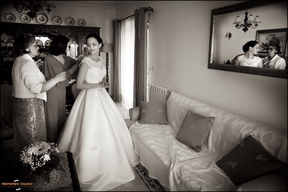 Mother, sister and bride with a mirror, with them, in the wall.
