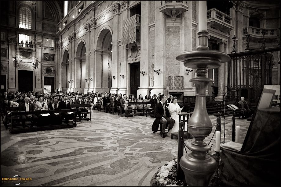 The magnificent Mafra's Basilica with priest, bride and groom and guests.
