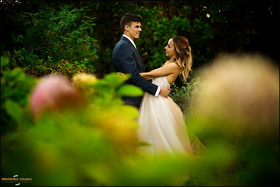 Couple, on their wedding day, among flowers at Quinta das Palmeiras in Sintra in the session with the wedding photographer in Portugal.