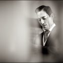 Portrait of the groom as he buttoned his coat sleeve. in a composition of the wedding photographer.