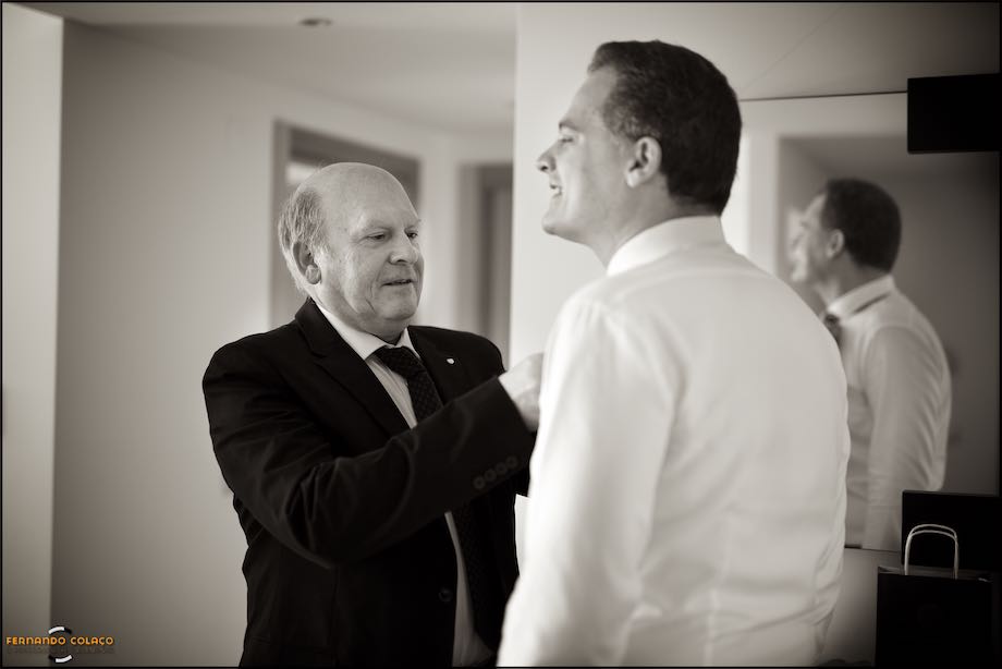 Father of the groom fine tune his tie in the get ready for the ceremony, captured by the wedding photographer in Lisbon.