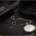 The pocket watch next to the belt and on the fabric of the groom's pants, in a composition by the wedding photographer.