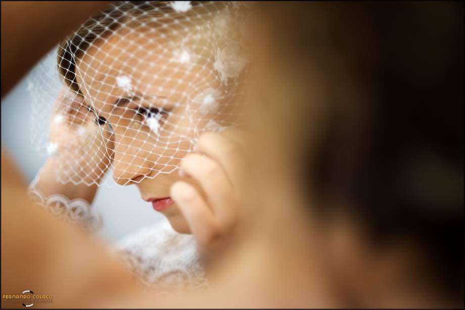 Bride fixing the veil mask before leaving for the wedding ceremony.