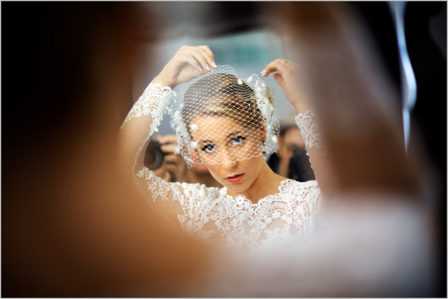 Bride puts the final touch on the veil mask.