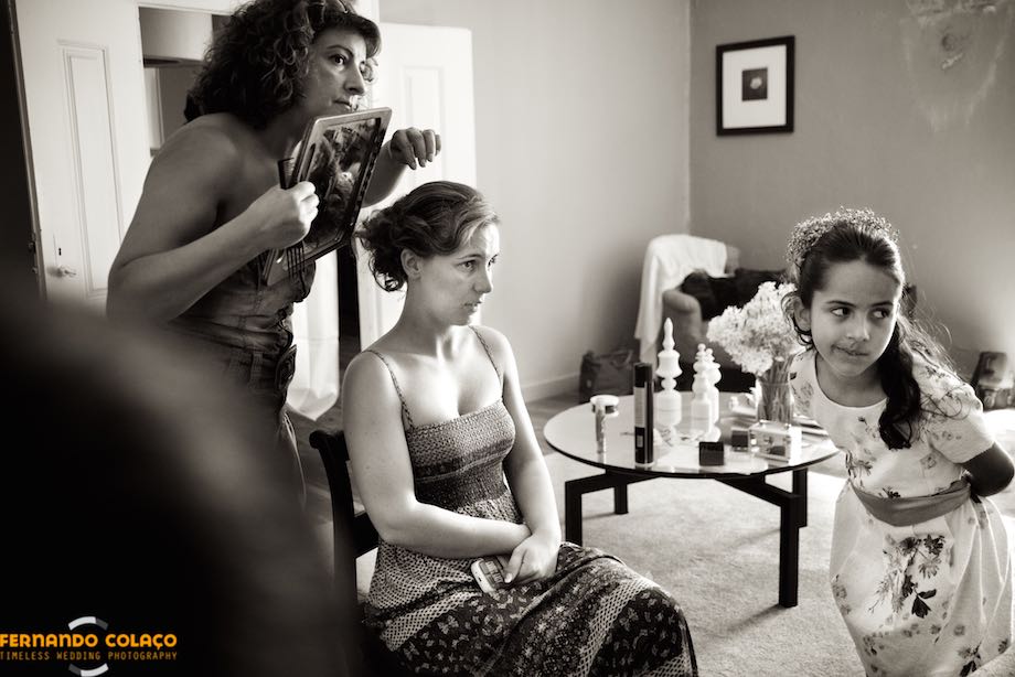 The bride, the hairdresser and a girl verifying the work on her hair, for the wedding at Quinta da Taipa in Alenquer.