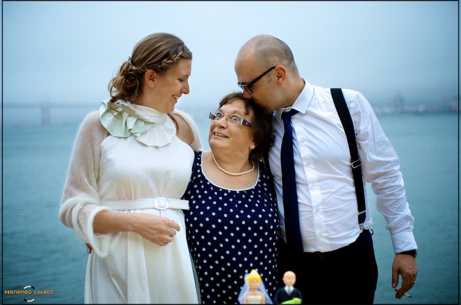 The groom kisses the hair of a neighbor of the parents, very dear to him, between him and the bride.