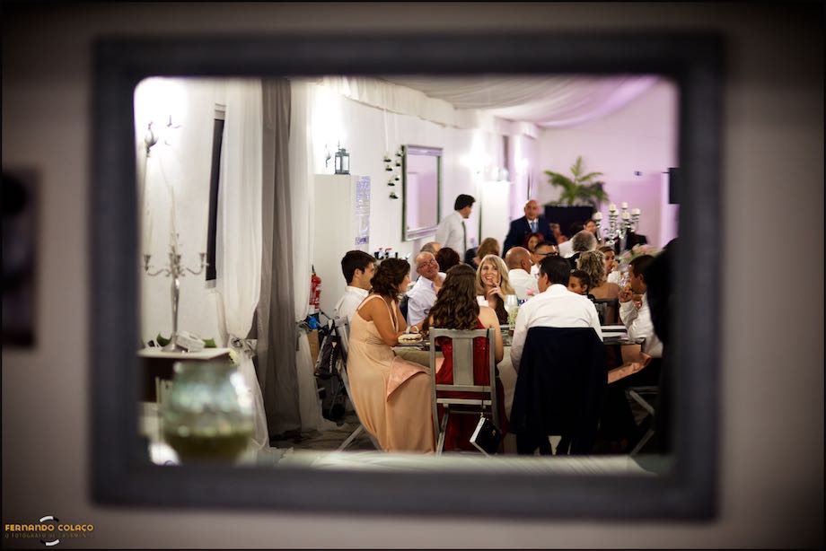 During the wedding meal, a young man in conversation with an adult, in the living room at Quinta da Cascata.