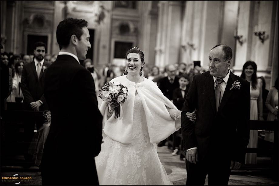Smiling bride with the father when arrive near the groom, at the altar of the wedding ceremony.