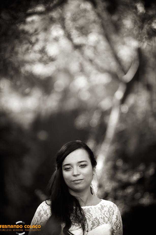 Bride in front of a blurred tree.
