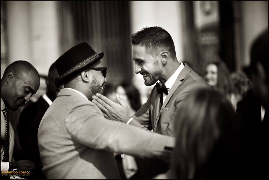 The groom exchanges affections with a friend at the end the wedding ceremony.