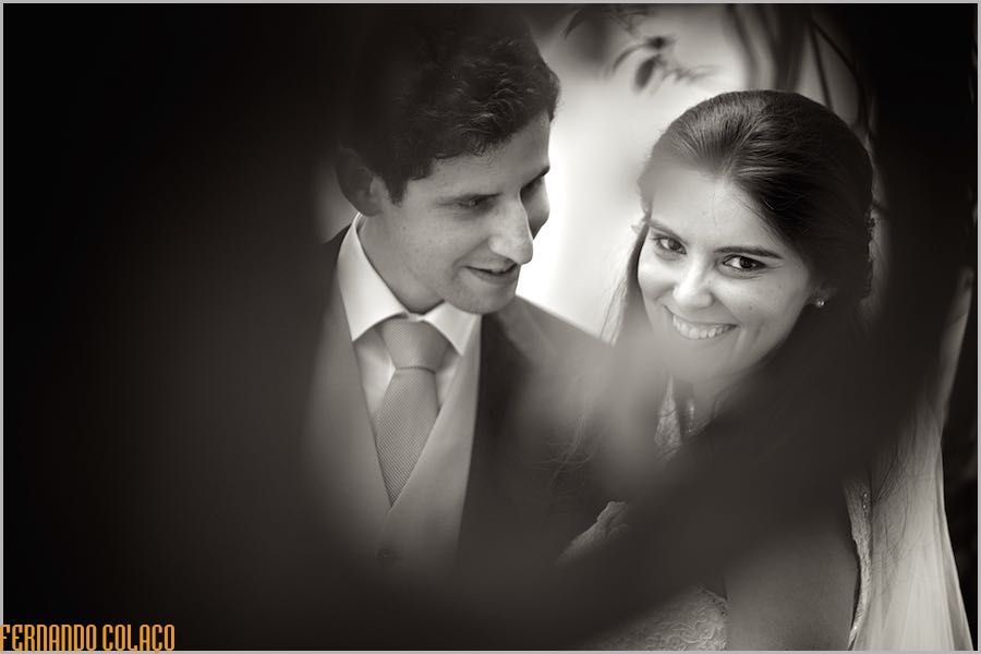 Perhaps, dating out under an olive tree at Quinta do Louredo in Évora, the newly married couple laugh together during the session with the wedding photographer.