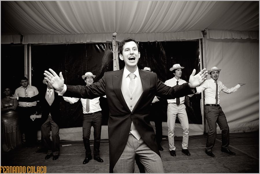 The groom in front of his friends, choreographing a dance, at the wedding party at Quinta do Louredo in Évora.