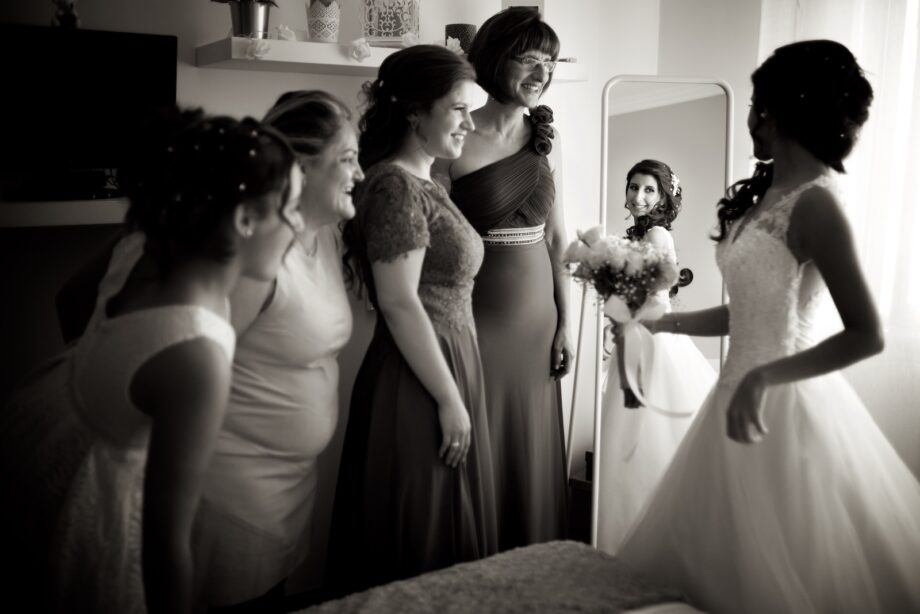 Bride in the mirror and being seen by happy friends.