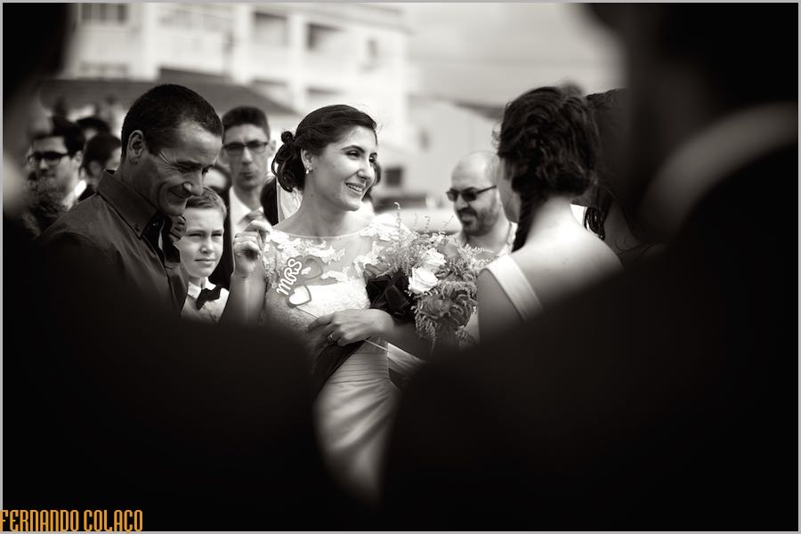 After the wedding ceremony, and already on the street, the bride is surrounded by guests who congratulate her, as seen by the wedding photographer in Lisbon.