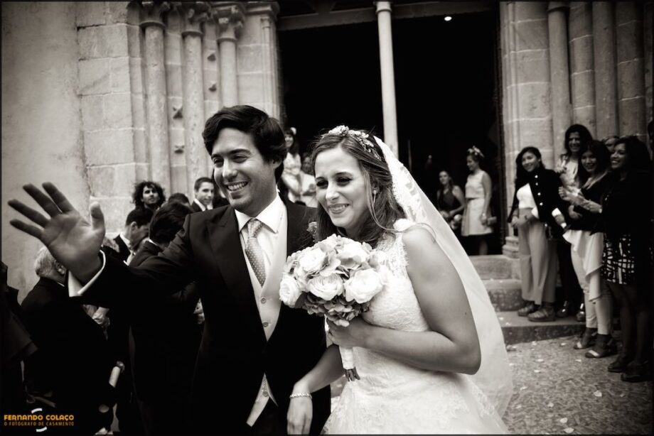 Juntos, os noivos, na saída da igreja ao chegarem perto dos seus convidados que esperam para os felicitar, vistos pelo fotógrafo de casamento em Sintra.