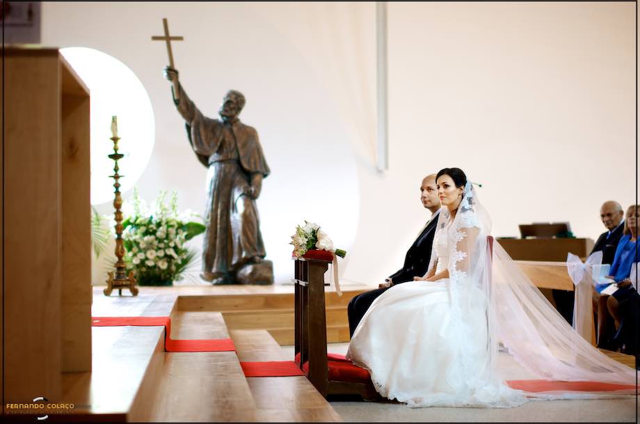 The bride and groom were seated in the ceremony by the statue of St. Francis of Assisi in the church of the same name in Restelo, seen by the wedding photographer in Lisbon.