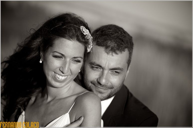 Retrato dos noivos juntos e abraçados na luz do fim de tarde na Praia da Sereia na Costa da Caparica, pelo fotógrafo de casamento em Lisboa.